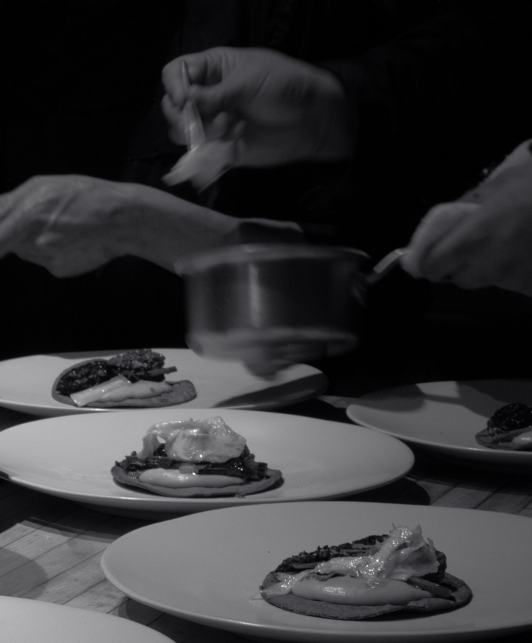 Chefs plating blue-corn tostadas at the Corima pass